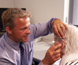 Doctor-Fitting-Hearing-Aids-for-Senior-Patient